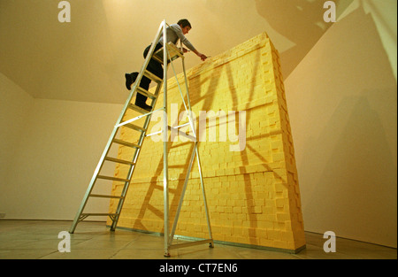 Künstlerin auf Leiter, Bildhauerei eine Wand komplett aus Butter gemacht. Es wog Dreiviertel Tonne und wurde mit Lotto Geld finanziert. Stockfoto