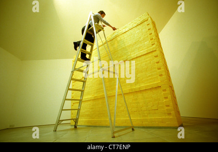 Künstlerin auf Leiter, Bildhauerei eine Wand komplett aus Butter gemacht. Es wog Dreiviertel Tonne und wurde mit Lotto Geld finanziert. Stockfoto