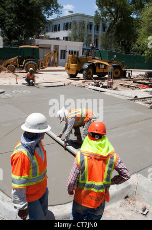 Gruppe von Hispanic männliche Arbeitnehmer komplette konkrete Bürgersteig vor der Villa des Gouverneurs von Texas in Austin, Texas Stockfoto