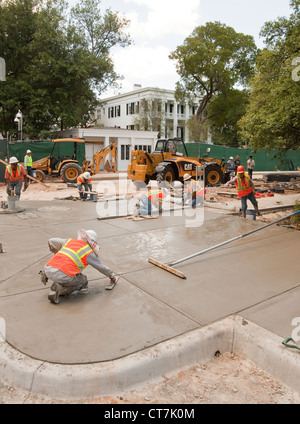 Hispanische männlichen Betonbauer komplette konkrete Bürgersteig vor der neu renovierten Texas des Gouverneurs in Austin, Texas Stockfoto