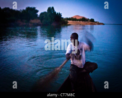 Ruderer, die Überquerung des Niger-Flusses in der Abenddämmerung von Dune Koima (Dune Rose), Region Gao. Mali. West-Afrika. Stockfoto