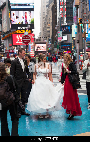 Junges Paar zu heiraten und mit Hochzeit Fotos, die auf dem Times Square in Manhattan, New York City Stockfoto