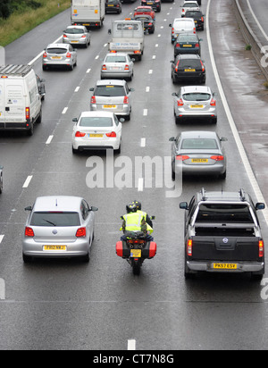 EIN MOTORRAD FILTERT DURCH STARKEN VERKEHR AUF DER AUTOBAHN M6 AUTOBAHN IN DER NÄHE VON STAFFORD RE SICHERHEIT ZWEI RÄDERN TRANSPORT HOHE SICHTBARKEIT UK Stockfoto