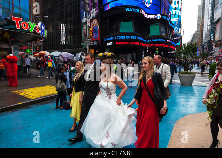 Junges Paar zu heiraten und mit Hochzeit Fotos, die auf dem Times Square in Manhattan, New York City Stockfoto