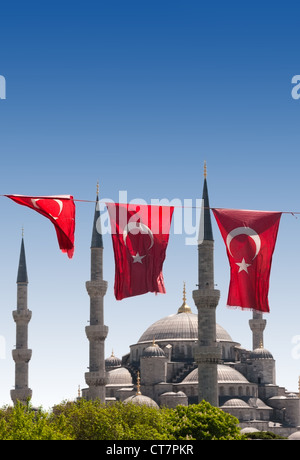 Moschee hinter Türkische Flaggen in blauer Himmel Stockfoto