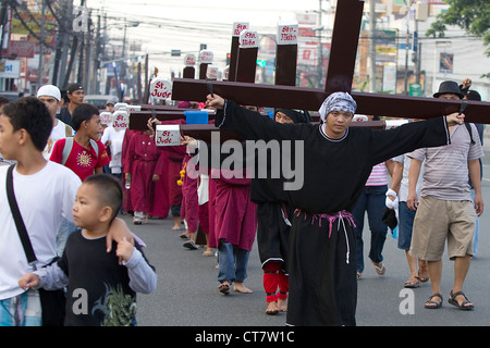 Büßer tragen hölzerne Kreuze während der Karwoche, Angeles City, Pampanga, Philippinen Stockfoto