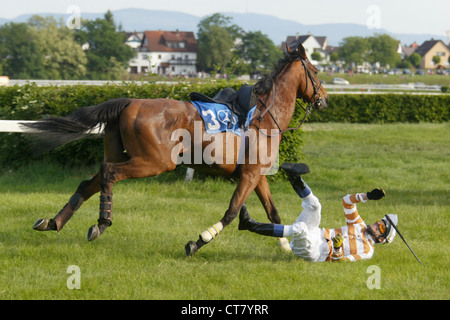 Ein Jockey stürzt aus dem Sattel seines Pferdes Stockfoto