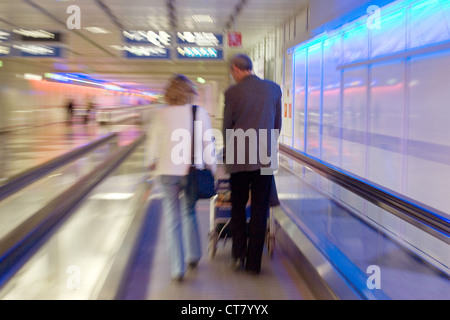 München, Reisende in einem Korridor von Muenchen Flughafen auf einer Rolltreppe Stockfoto