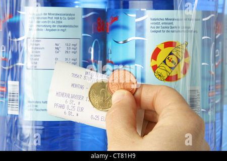 Hand mit Geld und Anzahlung Quittung vor Flaschen von LIDL Stockfoto