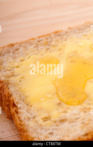 Scheibe Vollkornbrot mit Butter und Honig Stockfoto