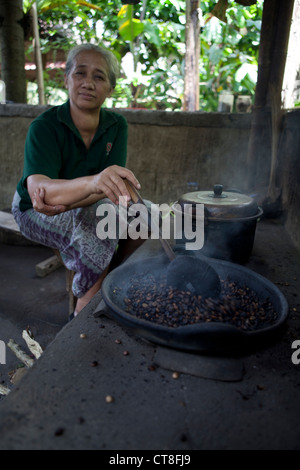 Eine balinesische Frau Rösten von Kaffeebohnen auf einer Plantage auf Bali Stockfoto