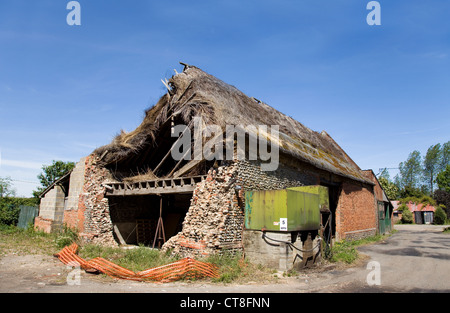Alte reetgedeckte & gefliest Bauernhof Scheune, die auf einem Hof in ländlichen Norfolk, Großbritannien zusammenbricht. Sehen Sie hier mit einem Diesel-Tank-Speicher Stockfoto