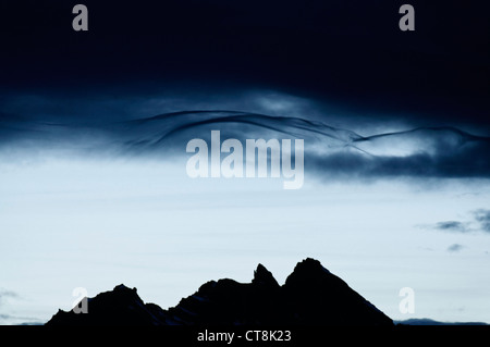Vom Wind verwehten Wolken bilden über eine Alpenkamm Stockfoto