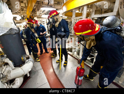 Die Seeleute erhalten eine Ausbildung von Chief Damage Controlman Dager Hatch während einer Feuerwehrausbildung Evolution an Bord des amphibischen Transportdocks USS New York (LPD 21). New York und die eingeschiffte 24. Marine Expeditionary Unit (24. MEU) sind Teil der Iwo Jima Amphibian Ready Group, die im Verantwortungsbereich der 5. US-Flotte maritime Sicherheitsoperationen und Zusammenarbeit im Bereich der Theatersicherheit unterstützt. Stockfoto