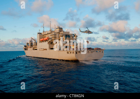 Ein US Navy SH-60 Seahawk Hubschrauber nimmt Paletten von Lieferungen von der Trockenladung und Munition Schiff USNS Amelia Earheart (T-AKE 6) während einer Nachschub auf See mit dem geführten Raketenzerstörer USS McCampbell (DDG 85), nicht abgebildet, im East China Sea 8. Juli 2012. McCampbell war im Gange, um maritime Sicherheitsoperationen und Theater-Sicherheitskooperationen in der 7. US-Flotte durchzuführen. Stockfoto