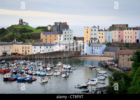 Tenby Hafen bei Flut mit Booten von bunt bemalten Regency-Häuser und das Schloss in der Abenddämmerung übersehen. Stockfoto