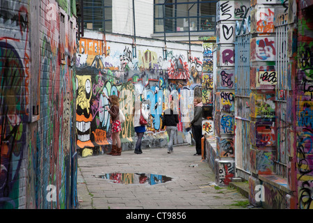 Gruppe von Mädchen spritzen Graffiti an einer Wand in Werregaren Straat - Straße in Gent, wo Graffiti legal Gent-Brüssel ist Stockfoto