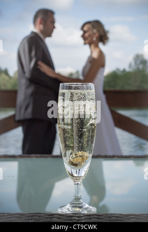 Nahaufnahme der Trauringe in einem Glas Champagner Stockfoto