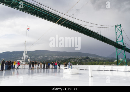 Kreuzfahrtschiff Volendam, das unter der Lion's Gate Bridge im Hafen von Vancouver, British Columbia, Kanada, vorbeifährt, mit sehr wenig sichtbarem Abstand. Stockfoto