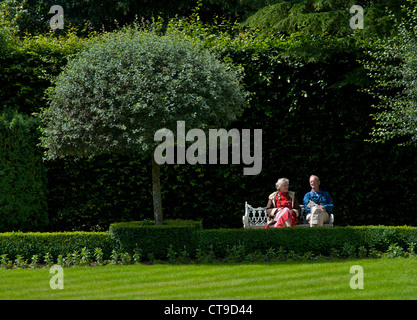 Zwei Menschen sitzen in den formalen Gärten bei Holker Hall, South Lakeland, Cumbria, England UK Stockfoto