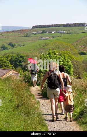 Wandern mit Kindern (einer im Rucksack) planmäßig von Pendle Hill Gerste Dorf, Lancashire, England, UK Stockfoto