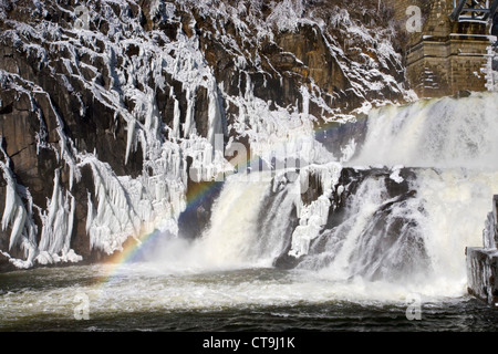 Regenbogen am Fluss Wasserfall im winter Stockfoto