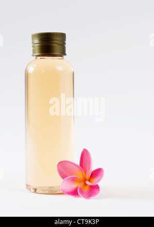Nahaufnahme von Flasche und Frangipani auf weißem Hintergrund Stockfoto