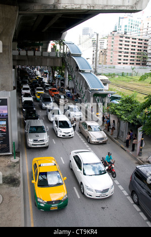 Schwerlastverkehr auf der Thanon Sukhumvit Road unter Nana Skytrain Station in Bangkok, Thailand Stockfoto