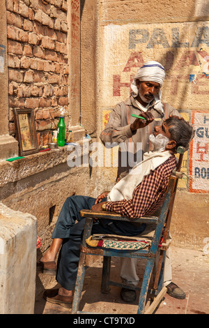 Der Barbier rasieren auf der Ghat Varanasi, Uttar Pradesh, Indien Stockfoto