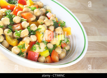 Küken-Erbse-Salat in einer Schüssel auf einem Holztisch sitzend. Stockfoto