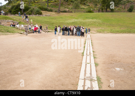 Touristen an der Startlinie des ursprünglichen Olympiastadion, Olympia, Griechenland Stockfoto