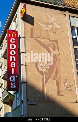 Neue Fast-Food und alten sowjetischen Malerei an der Wand eines Gebäudes Târgu Mureș, Karpaten Siebenbürgen, Rumänien, Osteuropa, EU Stockfoto