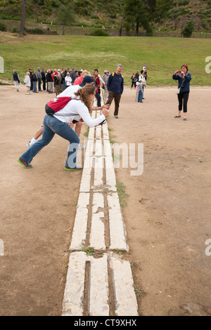 Touristen an der Startlinie des ursprünglichen Olympiastadion, Olympia, Griechenland Stockfoto