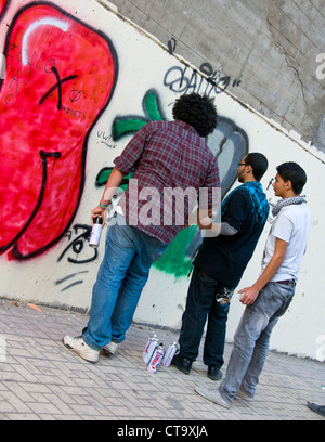 Junge Männer, die Zeichnung pro-revolutionäre Wandbild auf Mohammed Mahmoud Street Innenstadt von Kairo Ägypten Stockfoto