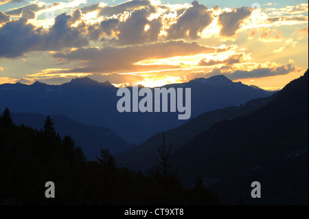 Die Sonne geht hinter einem Bergrücken der Berge in der Region Savoie der französischen Alpen. Stockfoto