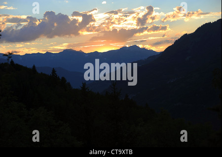 Die Sonne geht hinter einem Bergrücken der Berge in der Region Savoie der französischen Alpen. Stockfoto