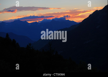 Die Sonne geht hinter einem Bergrücken der Berge in der Region Savoie der französischen Alpen. Stockfoto