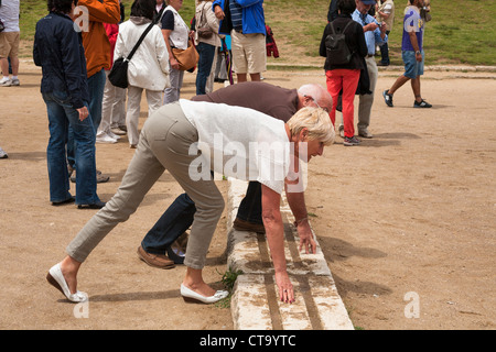 Touristen an der Startlinie des ursprünglichen Olympiastadion, Olympia, Griechenland Stockfoto