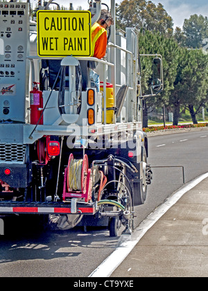 Striping Straßenmarkierungsfarbe wird erneut auf Fahrspuren auf einer Straße in Laguna Niguel, CA, mit einem speziell entwickelten LKW angewendet, Stockfoto