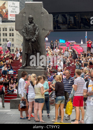 Touristen kommen in Duffy Square, der obere Teil des Times Square in New York City.  Beachten Sie die Statue von Vater Francis Duffy. Stockfoto