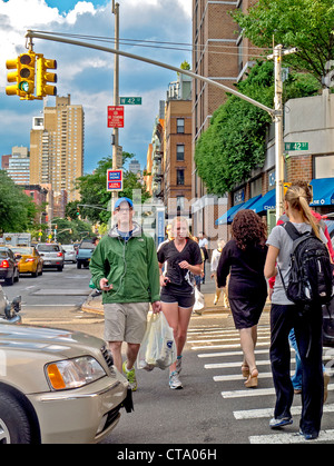 Fußgänger und Jogger Teilen einem Zebrastreifen auf der West 42nd Street in Midtown Manhattan, New York City. Stockfoto