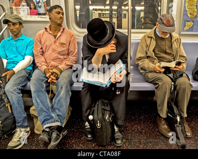 Orthodoxer Jude liest ein Buch auf Hebräisch, ein älterer Mann liest, ein Taschenbuch und zwei spanischen Arbeiter nur scheinen gelangweilt auf u-Bahn. Stockfoto