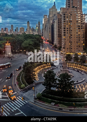 Die Brunnen von Columbus Circle in New York City Funkeln bei Dämmerung mit Blick auf Central Park South, und dem Central Park auf der linken Seite. Stockfoto