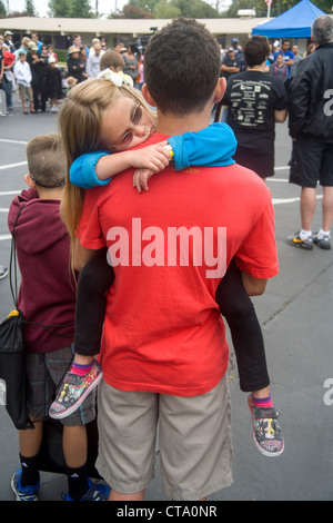 Eine Mädchen umarmt ihr Vater bei einer Fundraising-Veranstaltung für Kinder mit Sehstörungen in Santa Ana, CA. Hinweis getönte Gläser. Stockfoto