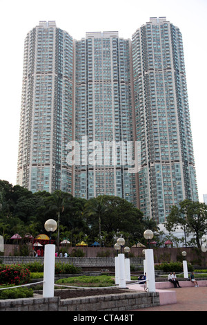 Es ist ein Foto von einer Gruppe von Türmen in Hong Kong mit einigen Bäumen herum. Wir sehen einen Park. Flache Ebenen Stadttürme grün Stockfoto