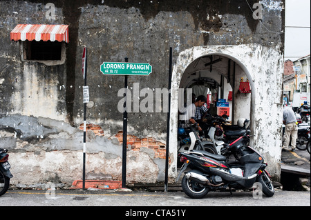 Die meisten Verkehr in den Straßen von Georgetown Penang ist Motorräder und Fahrräder und einige Riksjas. Stockfoto
