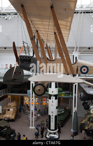 Zuschauer Fuß durch den ersten Stock Displays der Weltkrieg l und ll militärische Ausrüstung auf der Ausstellung mit einer britischen WW l Bi-Ebene. Stockfoto