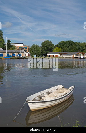 kleines Boot festgemacht an der Themse mit dem Hampton Wick am Fluss im Hintergrund Stockfoto