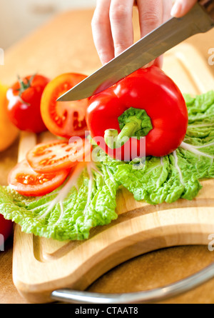 Frauenhand Tomaten Paprika, hinter frisches Gemüse schneiden. Stockfoto