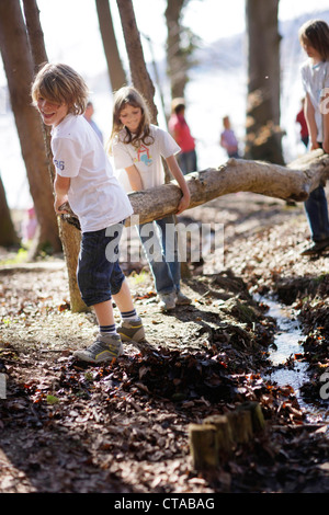 Entlang des Seeufers, spielende Kinder, die über einen Bach springen erdet Leoni Burg, Leoni, Berg, Starnberger See, Bayern, Deutschland Stockfoto